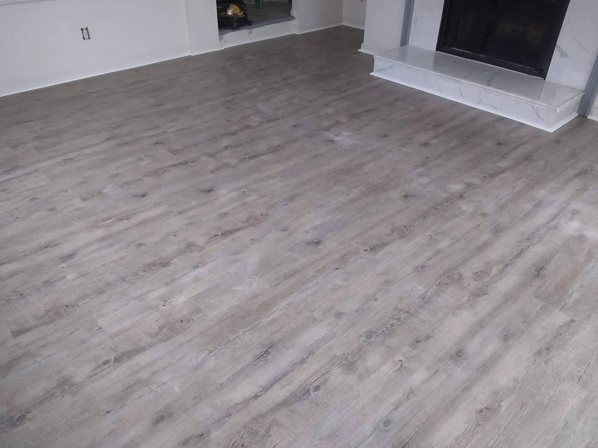 Living room with gray vinyl plank flooring and fireplace