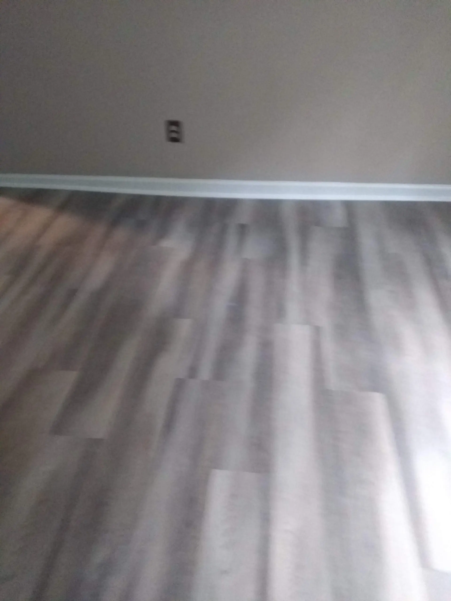 Wide room finished with gray vinyl plank flooring